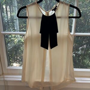 Theory sleeveless cream top with black tie detail.